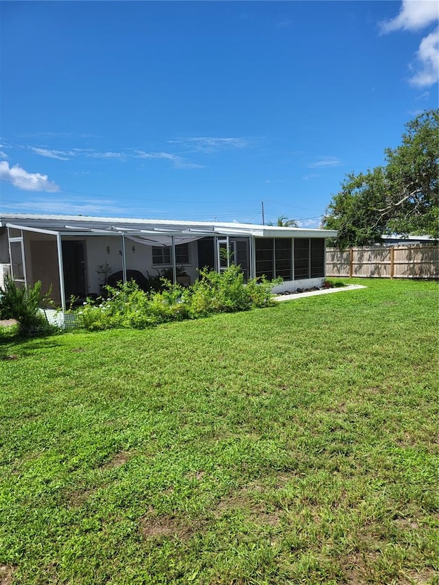 back of property with a sunroom and a lawn