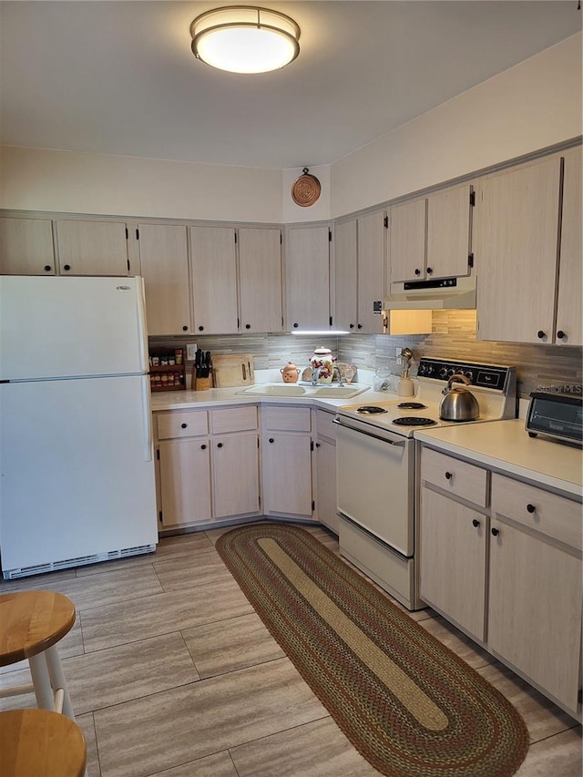 kitchen with decorative backsplash, white appliances, and sink