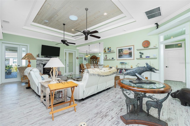 living room with a fireplace, a tray ceiling, crown molding, and wooden ceiling