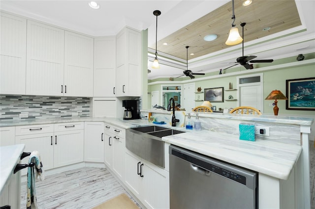 kitchen with light stone counters, stainless steel dishwasher, hanging light fixtures, white cabinetry, and ornamental molding