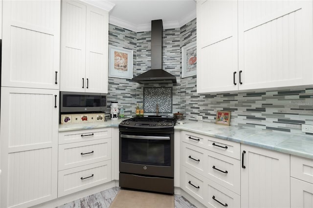 kitchen featuring white cabinets, wall chimney exhaust hood, ornamental molding, backsplash, and gas stove