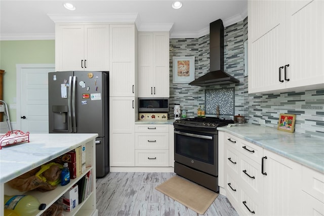 kitchen featuring white cabinetry, backsplash, wall chimney range hood, crown molding, and appliances with stainless steel finishes