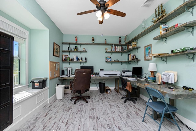 office area featuring built in desk, ceiling fan, and light hardwood / wood-style flooring