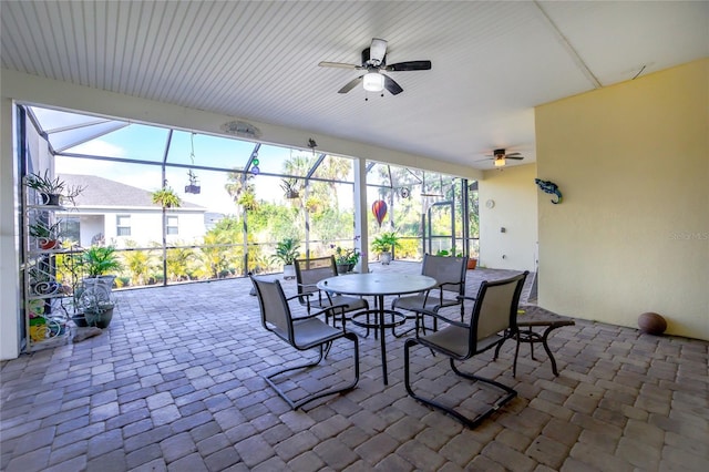 view of patio with ceiling fan and glass enclosure