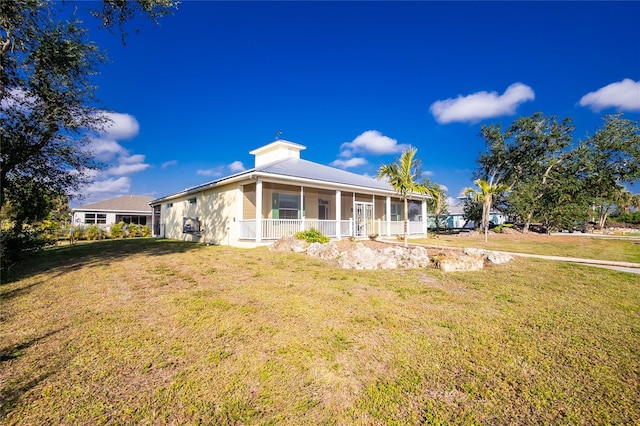 view of front of property featuring a sunroom and a front lawn