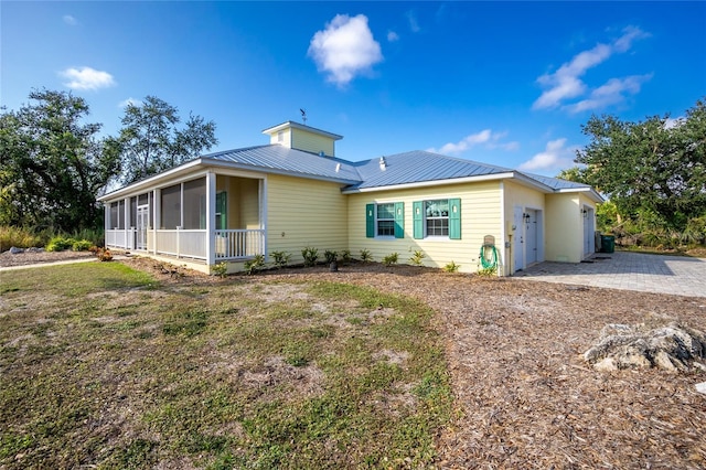 view of front of property featuring a garage and a sunroom