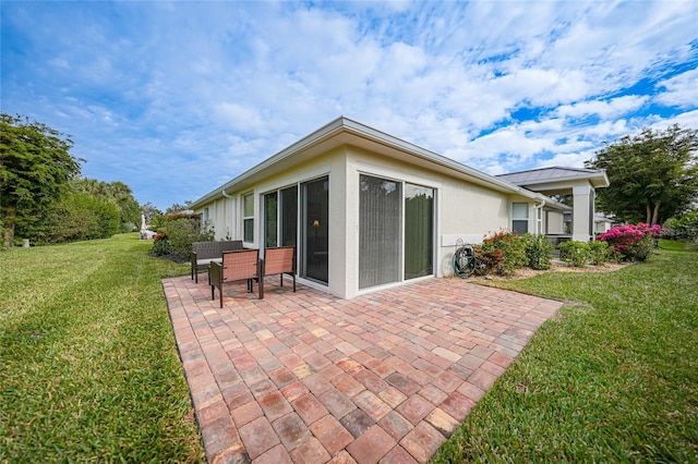 rear view of house featuring a yard and a patio