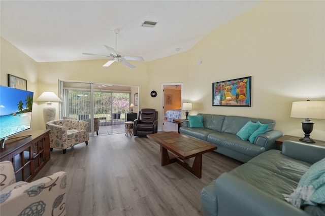 living room with hardwood / wood-style flooring, ceiling fan, and lofted ceiling