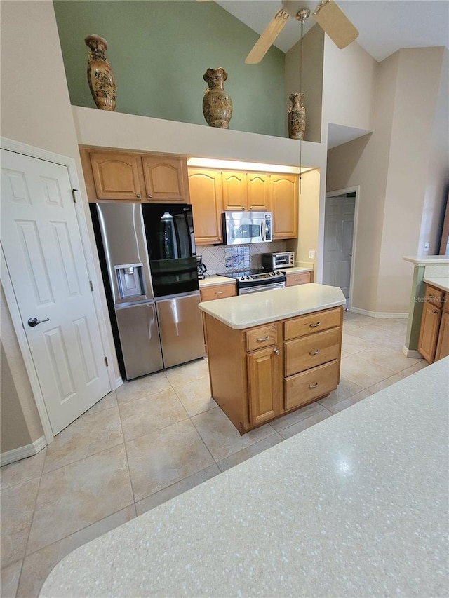 kitchen featuring light tile patterned floors, tasteful backsplash, high vaulted ceiling, a kitchen island, and appliances with stainless steel finishes