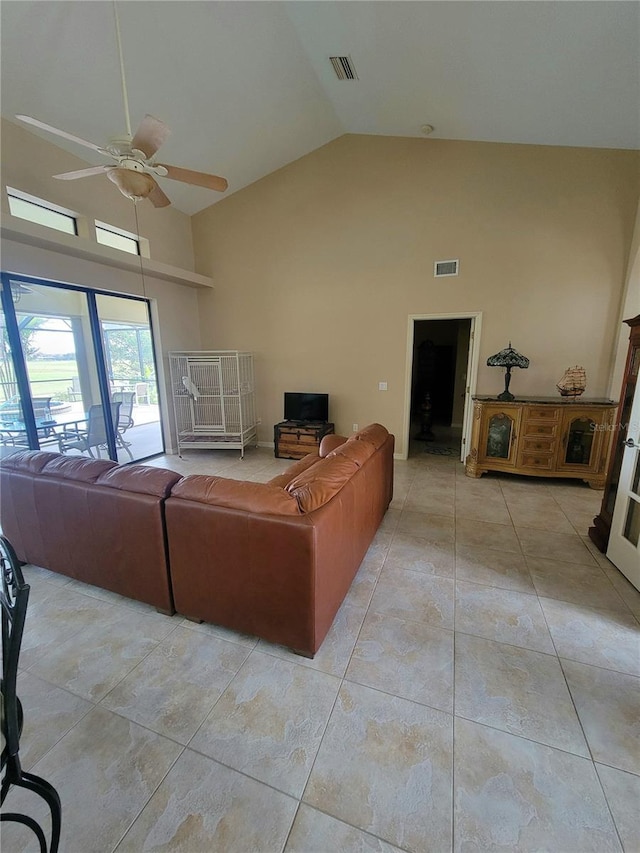 tiled living room featuring ceiling fan and high vaulted ceiling