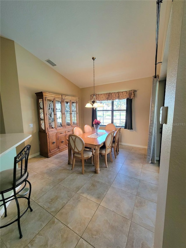 dining area with light tile patterned floors, lofted ceiling, and a notable chandelier