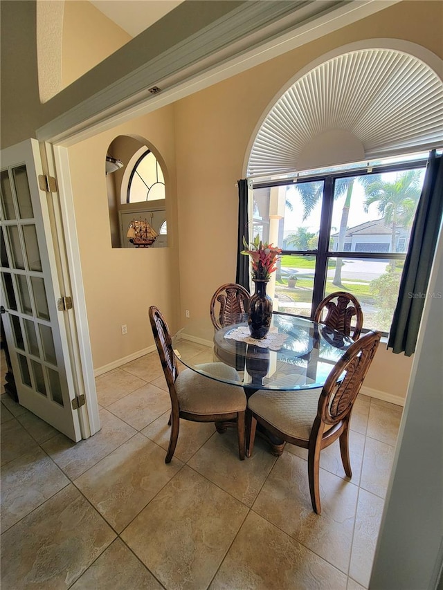 dining area with light tile patterned flooring and french doors