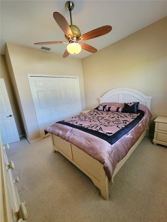 carpeted bedroom with ceiling fan and a closet