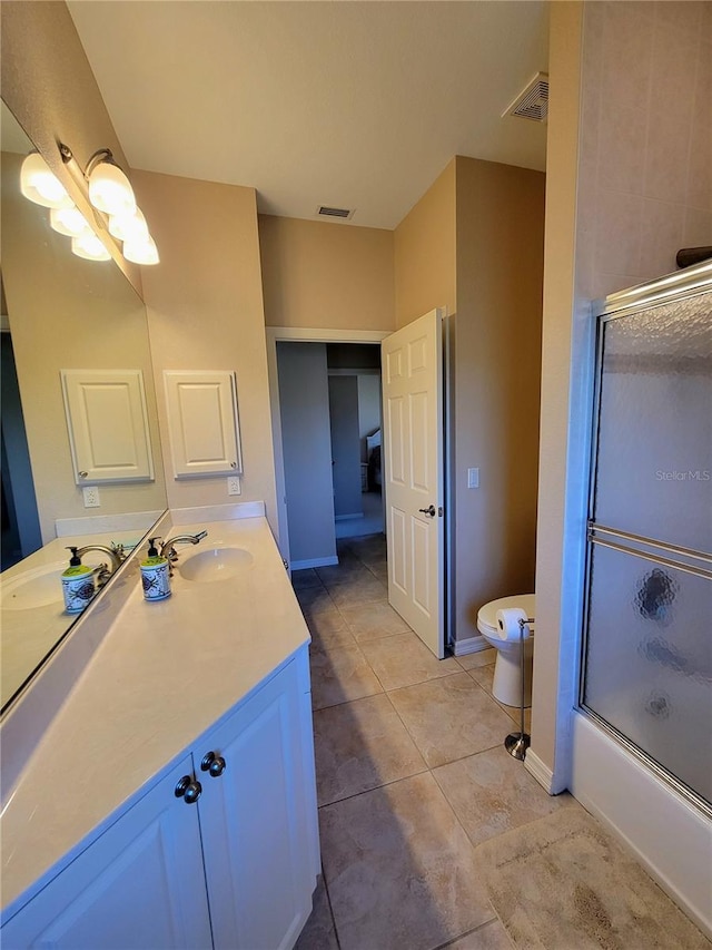 full bathroom with tile patterned flooring, vanity, toilet, and enclosed tub / shower combo