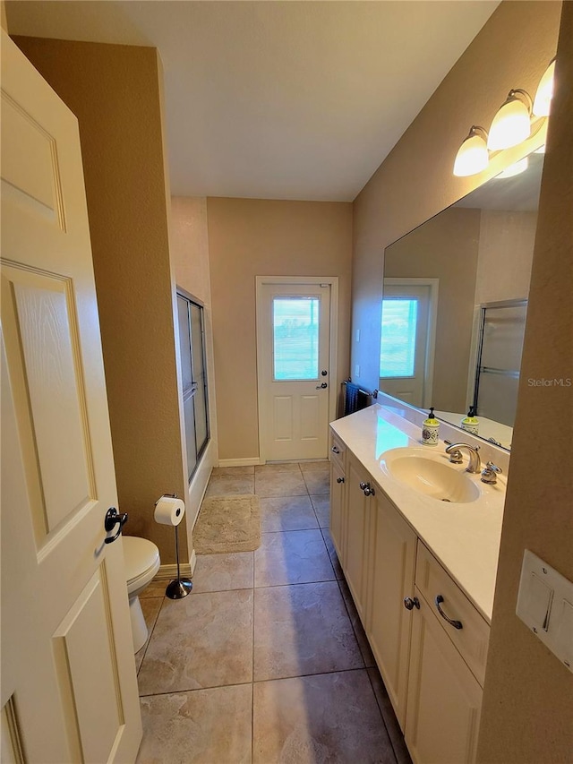 bathroom with toilet, vanity, tile patterned floors, and an enclosed shower