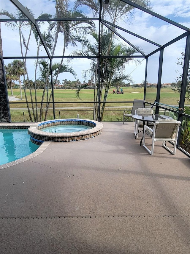 view of pool featuring glass enclosure, a yard, an in ground hot tub, and a patio