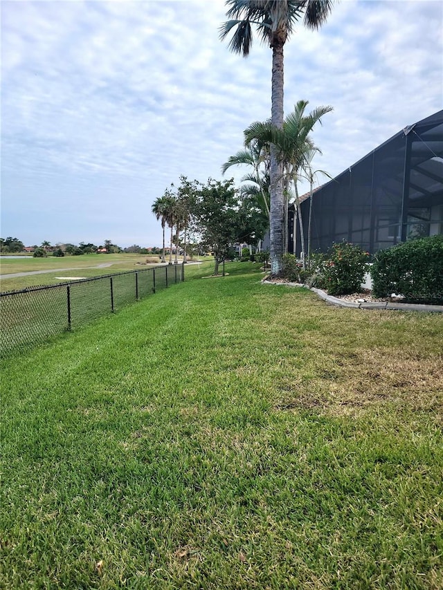 view of yard featuring a rural view and glass enclosure