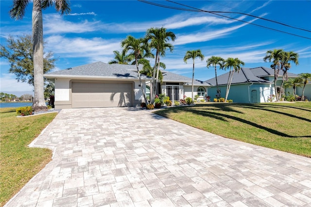 ranch-style house featuring a front yard, a water view, and a garage