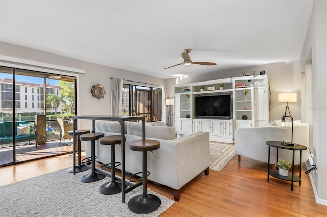 living room with light hardwood / wood-style flooring and ceiling fan