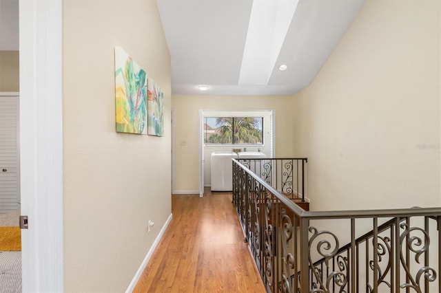 hall featuring light wood-type flooring and a skylight