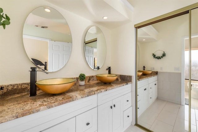 bathroom featuring tile patterned floors, vanity, and tile walls