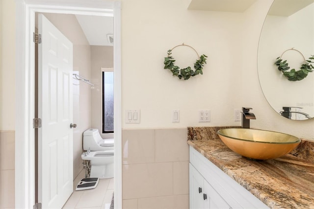 bathroom with tile patterned floors, vanity, toilet, and a bidet