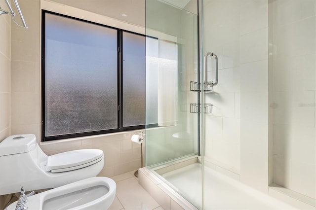 bathroom with a bidet, tile walls, tile patterned flooring, toilet, and a shower with shower door