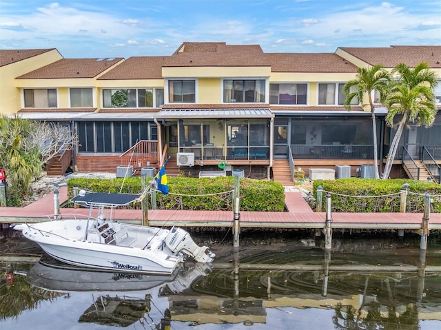 rear view of property with a water view, cooling unit, and a sunroom