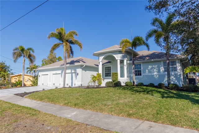 view of front of property featuring a garage, stucco siding, driveway, and a front yard