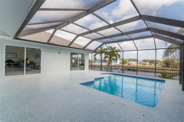 view of pool featuring a water view, a patio, and a lanai