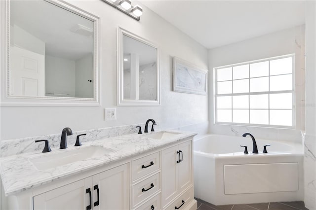 full bath featuring a garden tub, double vanity, and a sink