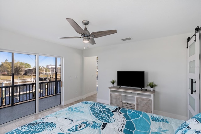 bedroom with access to exterior, visible vents, a barn door, a ceiling fan, and baseboards