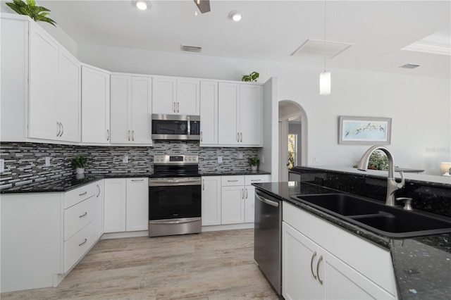 kitchen with white cabinetry, sink, dark stone countertops, pendant lighting, and stainless steel appliances