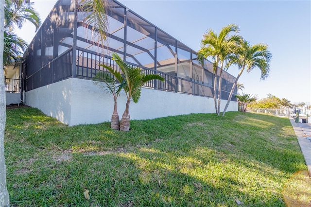 view of side of property featuring a yard, a lanai, and stucco siding