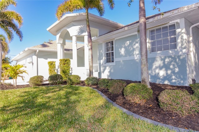 view of property exterior with a lawn and stucco siding