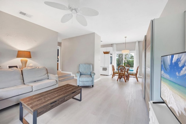 living room with ceiling fan and light hardwood / wood-style flooring