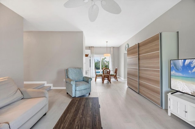 living room with ceiling fan and light hardwood / wood-style flooring