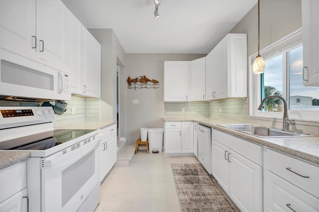 kitchen featuring hanging light fixtures, sink, white cabinets, white appliances, and decorative backsplash