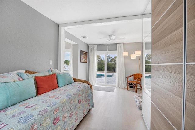 bedroom with ceiling fan, access to exterior, and light hardwood / wood-style floors