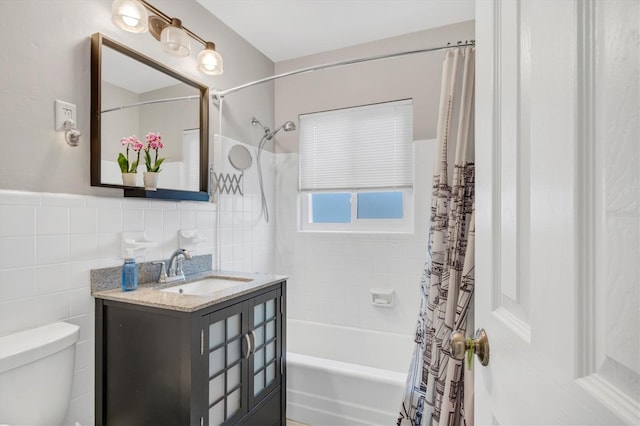 full bathroom with shower / bath combo, toilet, vanity, and tile walls