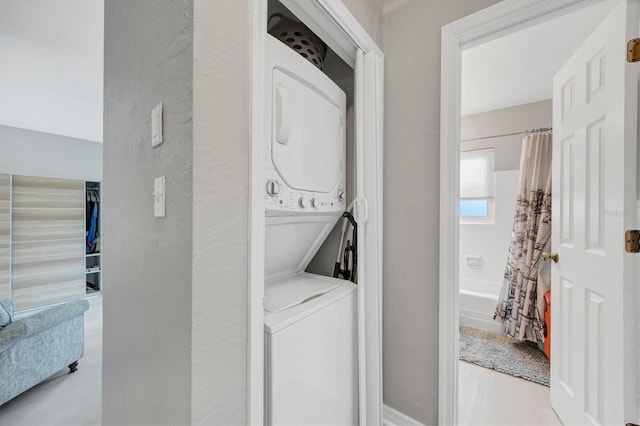 laundry area featuring stacked washer / drying machine