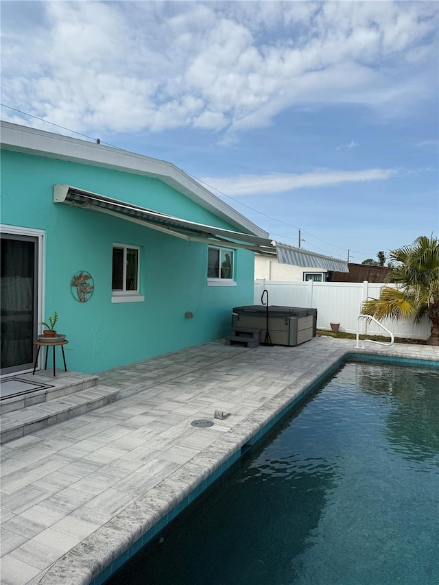 view of swimming pool with a patio and a hot tub