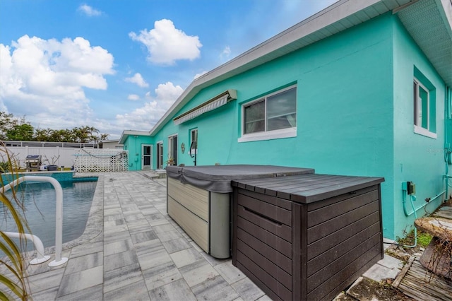 exterior space with a patio, a hot tub, and an outdoor bar