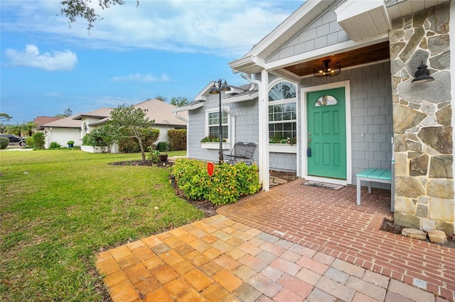 entrance to property featuring a yard and a patio area