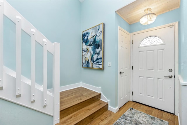 entryway with hardwood / wood-style floors and an inviting chandelier