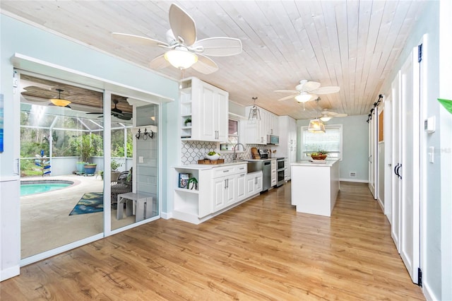 kitchen featuring light hardwood / wood-style floors, white cabinets, decorative backsplash, wooden ceiling, and a barn door