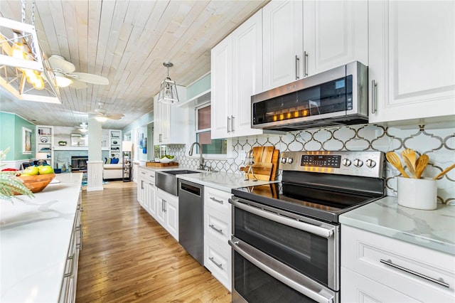 kitchen with sink, wood ceiling, appliances with stainless steel finishes, pendant lighting, and white cabinets