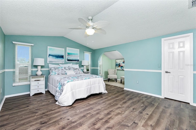 bedroom with dark hardwood / wood-style flooring, lofted ceiling, a textured ceiling, and ceiling fan