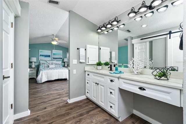 bathroom featuring vaulted ceiling, hardwood / wood-style floors, a textured ceiling, and ceiling fan