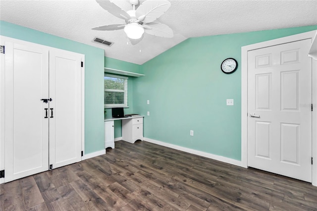 unfurnished bedroom with dark hardwood / wood-style flooring, a textured ceiling, vaulted ceiling, and ceiling fan